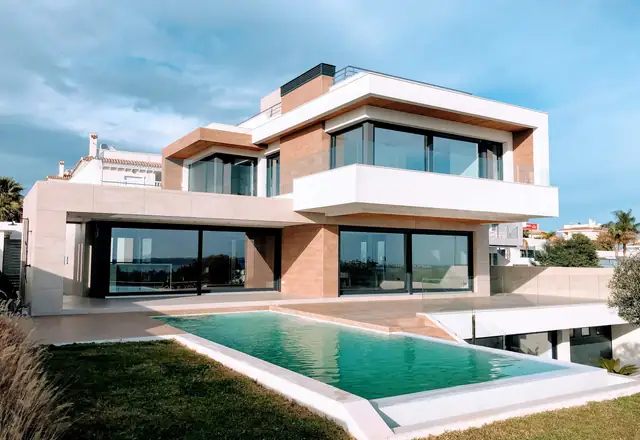 Modern two-story home with a pool at dusk