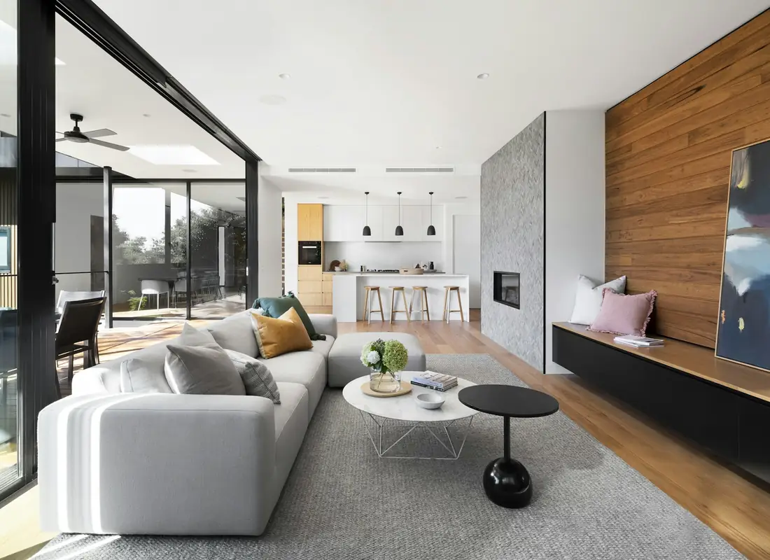 Living room with a white sofa, oak feature wall and glass doors